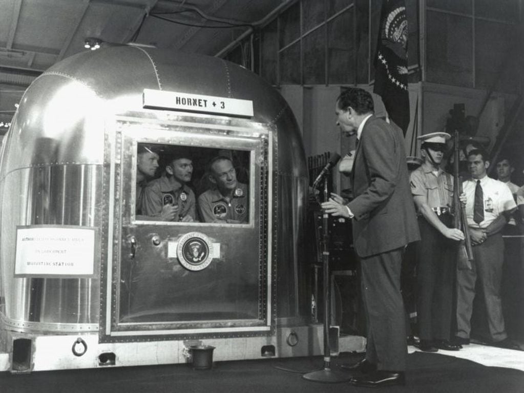 El presidente estadounidense Richard Nixon conversa con los astronautas del Apolo 11, aislados tras el regreso de la Luna a la Tierra, el 24 de julio de 1969 (foto gentileza NASA).