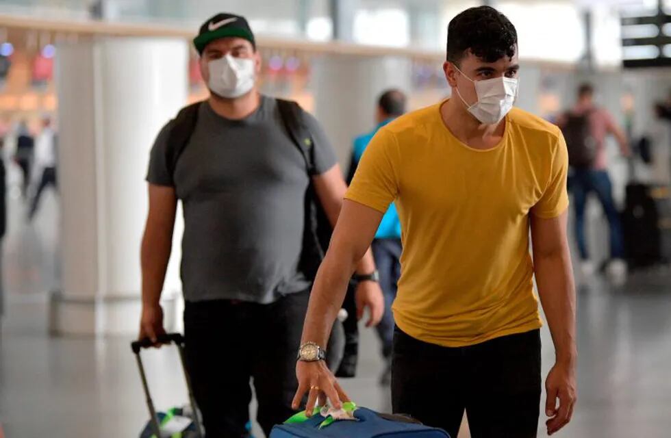 People wear protective face masks as a preventive measure against the spread of the new Coronavirus, COVID-19, at El Dorado airport in Bogota on March 7, 2020. (Photo by Raul ARBOLEDA / AFP)