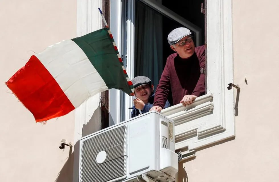 Rome (Italy), 25/04/2020.- People at the windows celebrate the 75th anniversary of Italy's Liberation in historical Testaccio neighborhood during the coronavirus lockdown in Rome, Italy, 25 April 2020. Italians will not be able to step out and celebrate the Liberation Day due to the nationwide lockdown to prevent the spread of the coronavirus disease (COVID-19) pandemic. (Italia, Roma) EFE/EPA/Riccardo Antimiani
