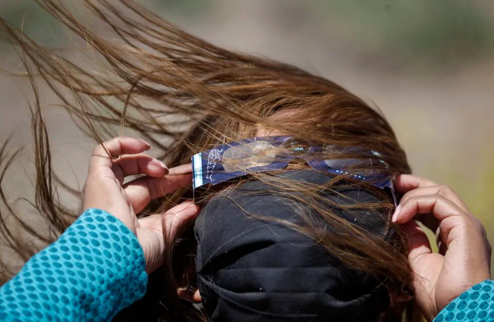 Una mujer con anteojos especiales para ver un eclipse solar total en Piedra del Águila, Neuquén, Argentina