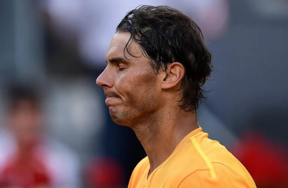 TOPSHOT - Spain's Rafael Nadal reacts after losing to Austria's Dominic Thiem during their ATP Madrid Open quarter-final tennis match at the Caja Magica in Madrid on May 11, 2018. / AFP PHOTO / OSCAR DEL POZO