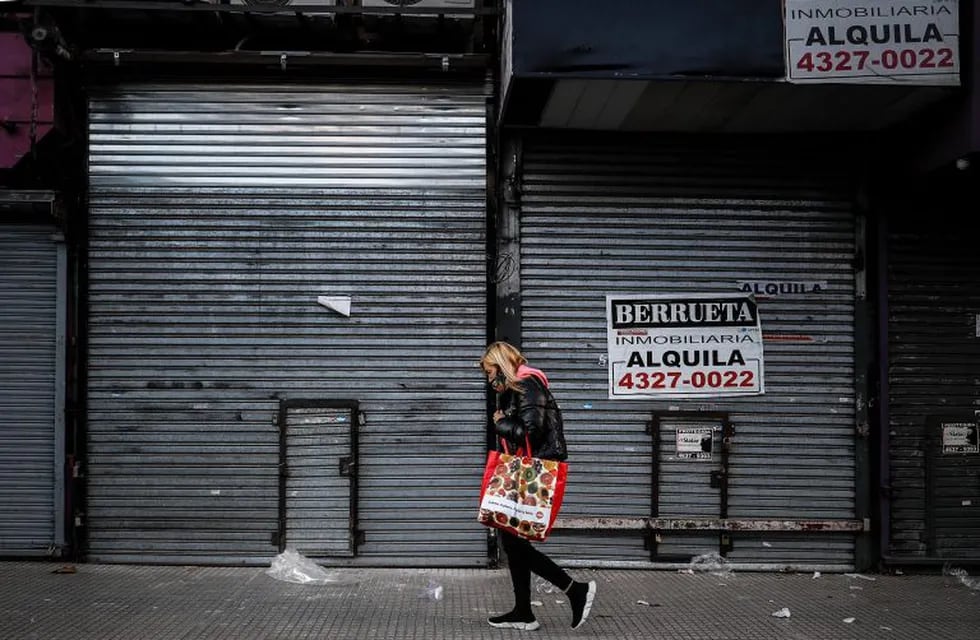 Una mujer camina frente a locales comerciales en el barrio de Once, hoy en Buenos Aires. (Foto: EFE/Juan Ignacio Roncoroni)
