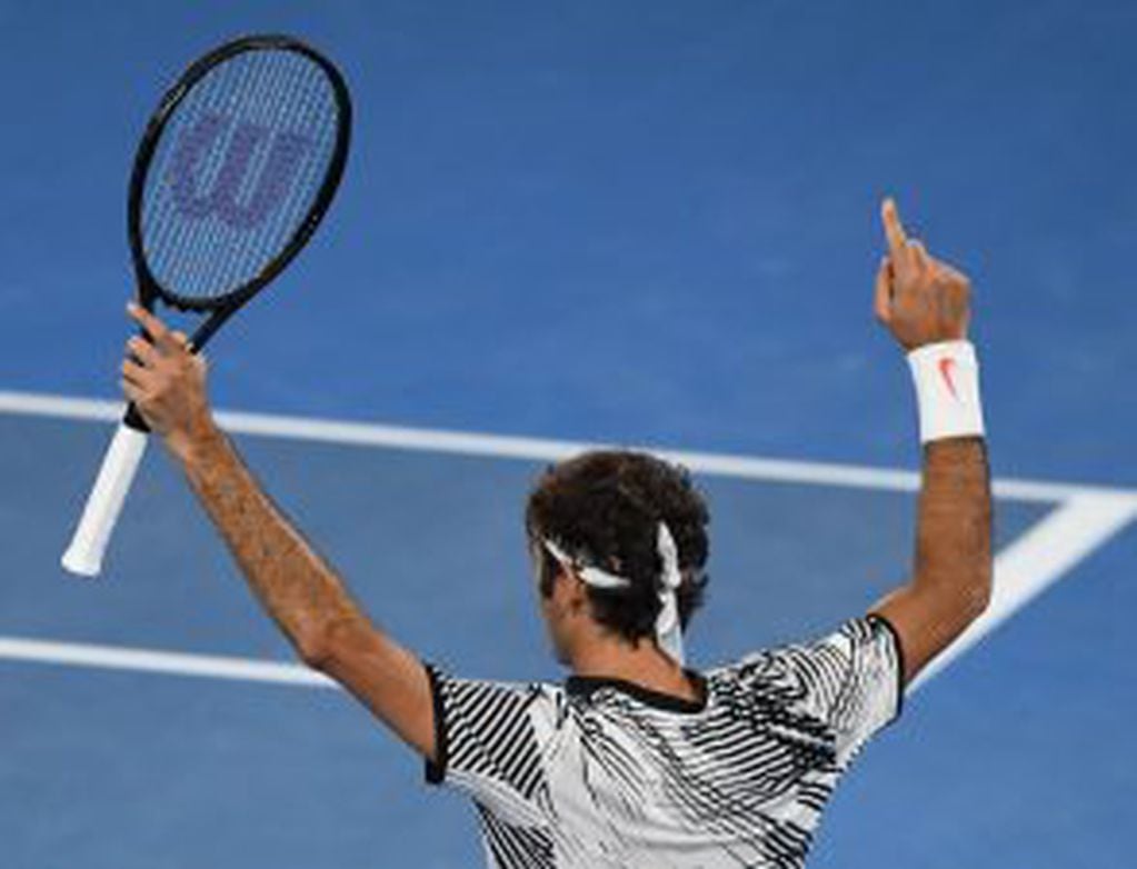 Switzerland's Roger Federer celebrates his win against Switzerland's Stanislas Wawrinka during their men's singles semi-final match on day 11 of the Australian Open tennis tournament in Melbourne on January 26, 2017. / AFP PHOTO / SAEED KHAN / IMAGE RESTR