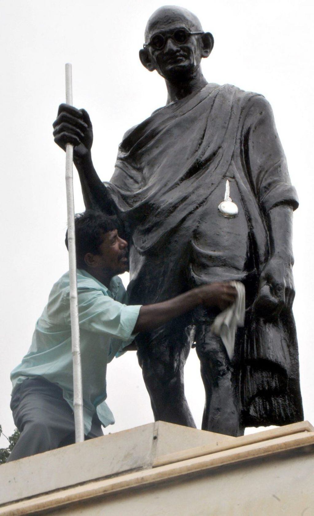 Un hombre limpia una estatua de Mahatma Gandhi la víspera de la celebración del Gandhi Jayanti, en Bangalore (India) EFE