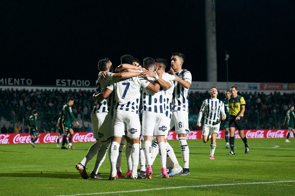 Diego Valoyes puso el 1-0 de cabeza para Talleres, sobre Sarmiento, y celebra con sus compañeros de equipo, en Junín. (Prensa Talleres)