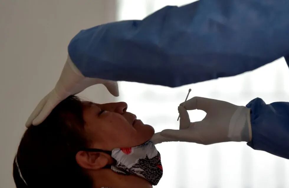 A health worker takes a sample for a COVID-19 test from a resident of the Kennedy neighborhood, one of the areas with the highest rate of positive cases in Bogota, on June 11, 2020. (Photo by Raul ARBOLEDA / AFP)   hisopado