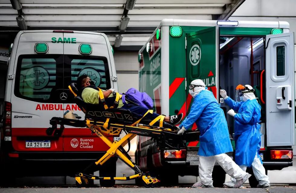 Argentine doctors Gonzalo Figueroa (R) and Hernan Chaile of the Medical Emergency System (SAME) of Buenos Aires move a patient with COVID-19 symptoms to a hospital in Buenos Aires, on May 20, 2020. - The number of COVID-19 cases in Argentina has raised to more than 9.000, while the mandatory quarantine imposed on March 20 is still fully applied in the capital Buenos Aires. (Photo by RONALDO SCHEMIDT / AFP)  coronavirus test casos del dia  laboratorio  testeos  PCR HISOPADO  ambulancia