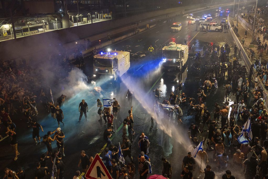 La policía antimotines intenta dispersar a manifestantes con un cañón hidrante durante una protesta contra el plan del gobierno de Benjamin Netanyahu de reformar el sistema judicial, en Tel Aviv, 24 de julio de 2023. Foto: AP / Oded Balilty.