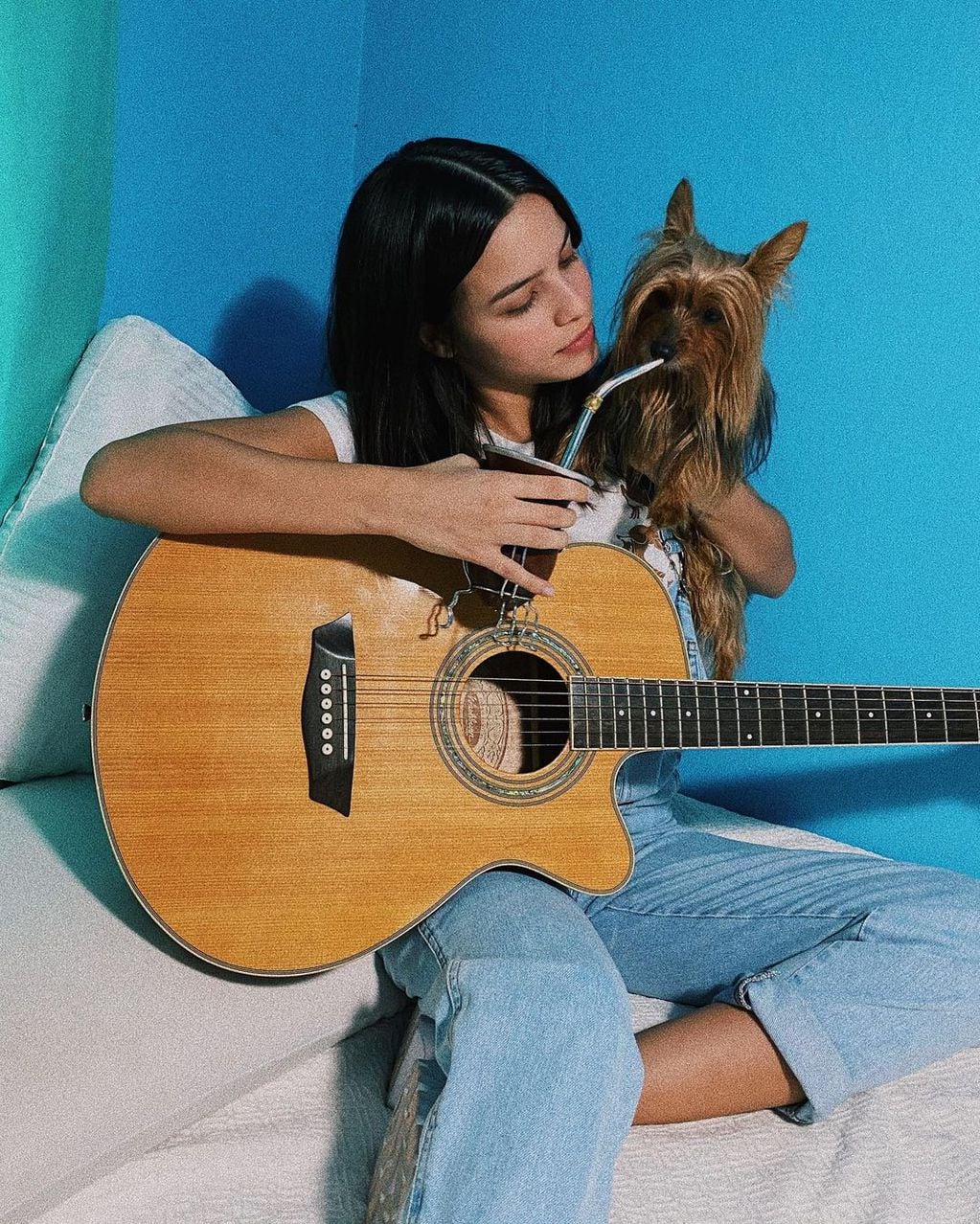 Emilia Mernes con su guitarra y su mascota