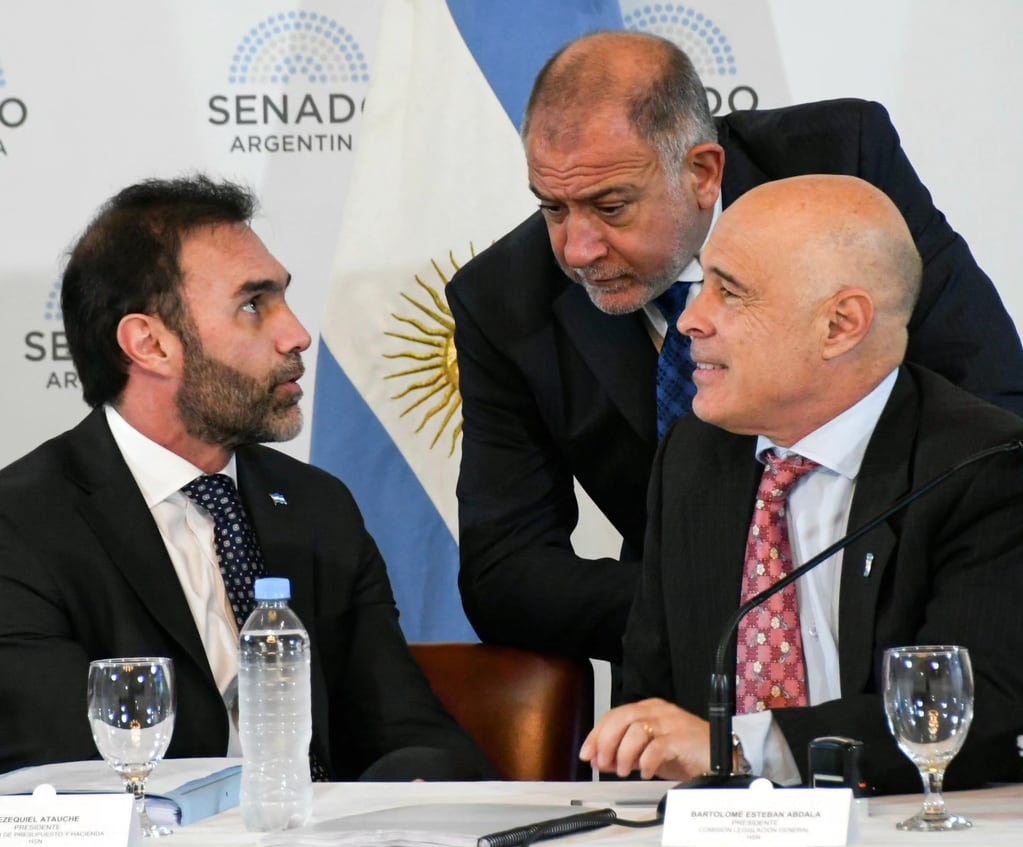 Los senadores Ezequiel Atauche (izq.), Luis Juez y Bartolomé Abdala (der.) intercambian opiniones sobre la Ley Bases en un plenario de comisiones del Senado.