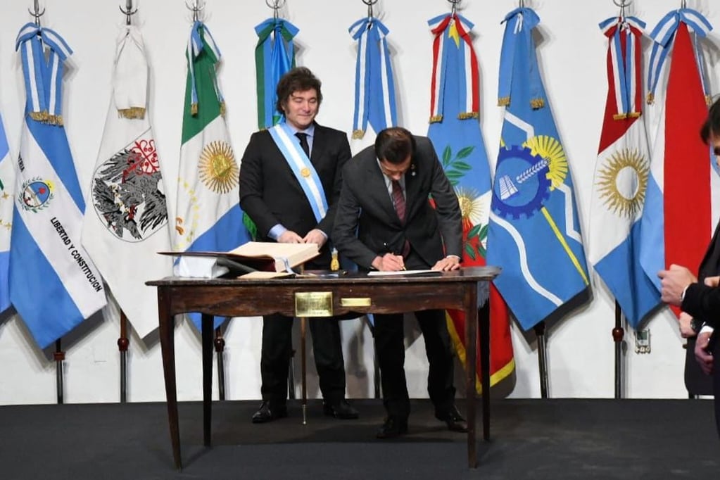 Momento en que el gobernador de Jujuy, Carlos Sadir, firma el Pacto de Mayo bajo la mirada atenta del presidente Javier Milei.