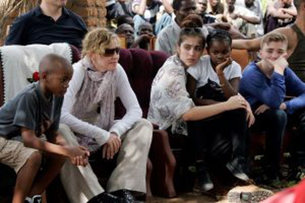 (FILES) This file photo taken on April 2, 2013 shows US Pop Star Madonna (2nd L) sitting with her biological and adopted children (L to R) David Banda, Lourdes, Mercy James, and Rocco at Mkoko Primary School, one of the schools Madonna's Raising Malawi or