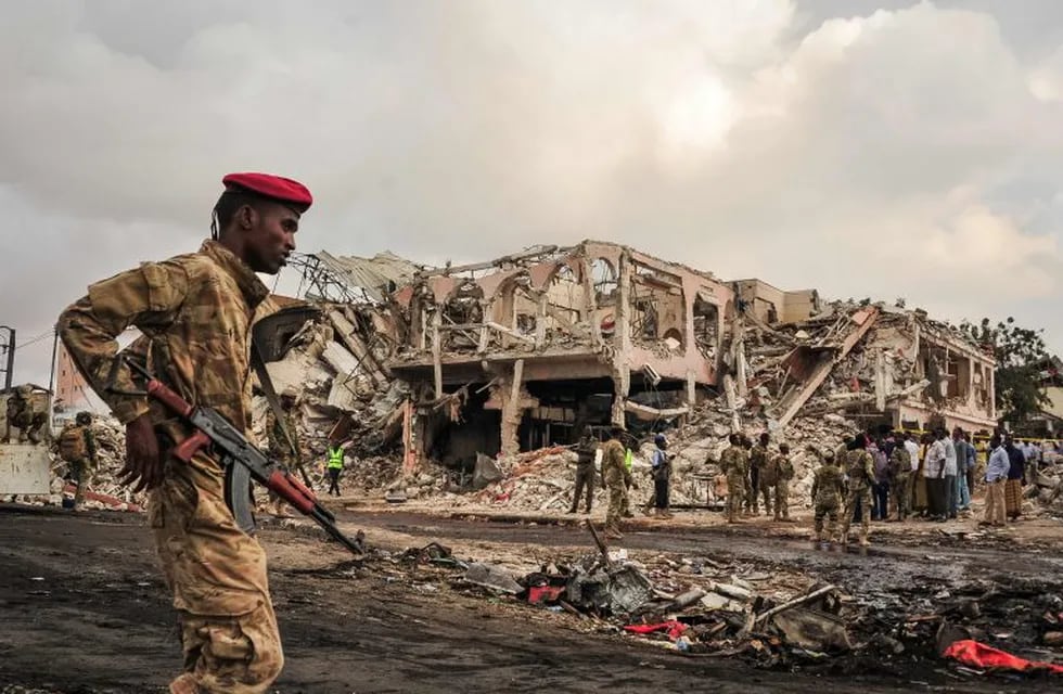 TOPSHOT - EDITORS NOTE: Graphic content / Somali soldiers patrol on the scene of the explosion of a truck bomb in the centre of Mogadishu, on October 15, 2017.\nA truck bomb exploded outside a hotel at a busy junction in Somalia's capital Mogadishu on October 14, 2017 causing widespread devastation that left at least 20 dead, with the toll likely to rise. / AFP PHOTO / Mohamed ABDIWAHAB