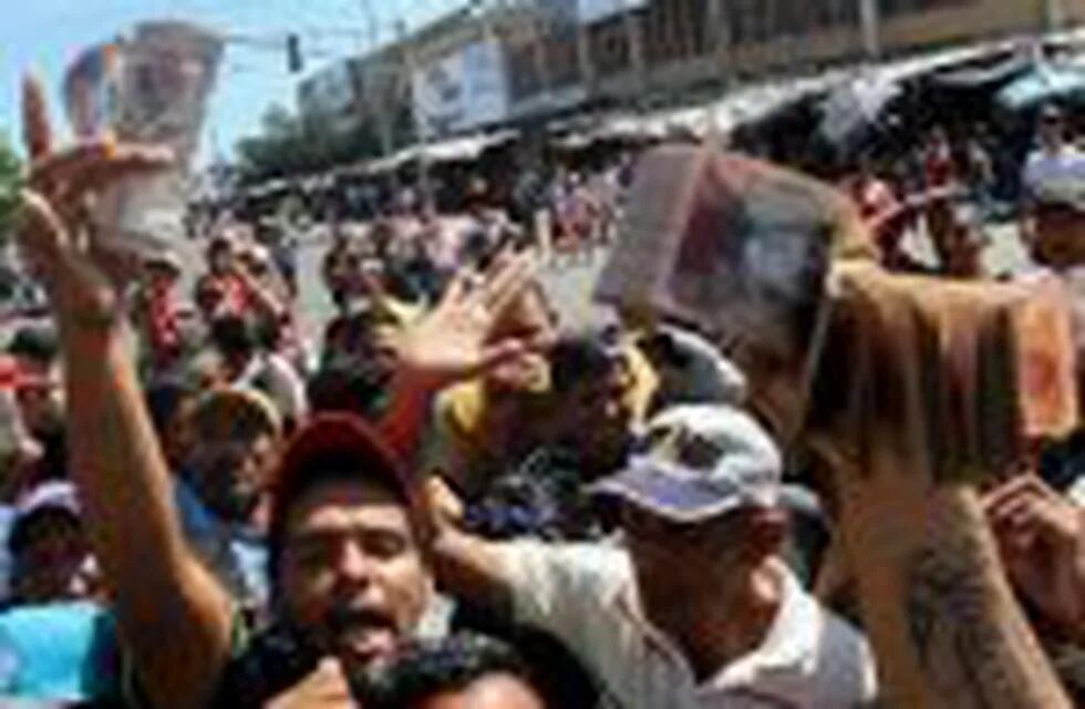 Handout picture released by courtesy of Panorama showing people protesting for lack of cash and new notes outside Venezuela's Central Bank (BCV) in Maracaibo city, Zulia State, on December 16, 2016.nVenezuelans lined up to deposit 100-unit banknotes befor