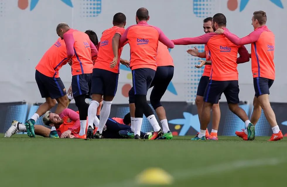 FC Barcelona's Lionel Messi, left on ground, reacts with his teammates during a training session at the Sports Center FC Barcelona Joan Gamper in Sant Joan Despi, Spain, Friday, Oct. 14, 2016. (AP Photo/Manu Fernandez)
