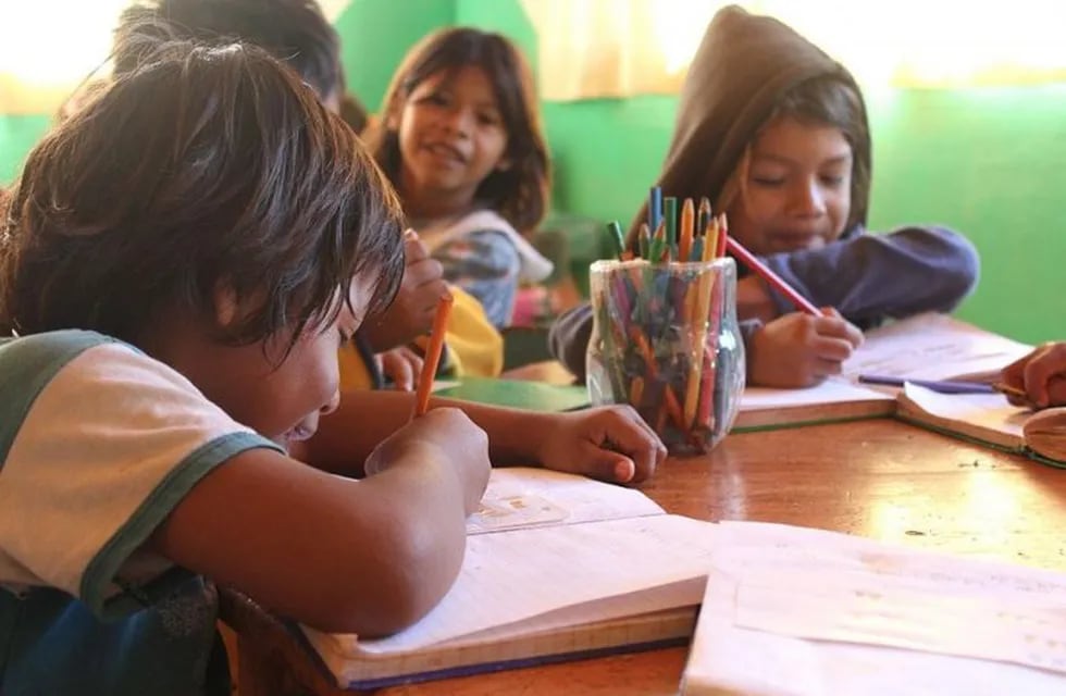 Nenes guaraníes reunidos para la tarea escolar.