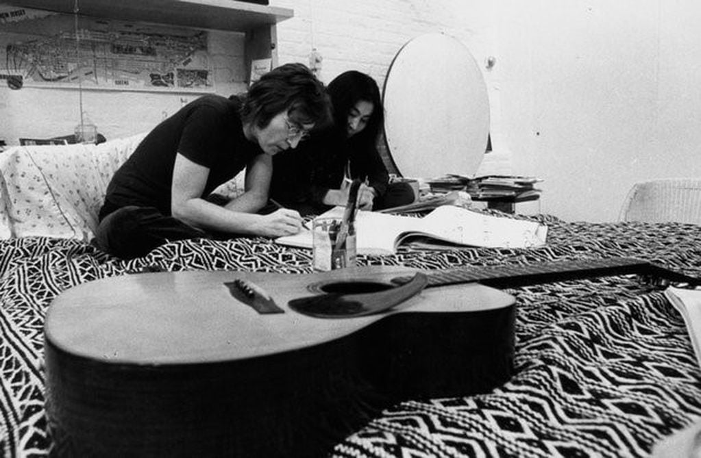 John Lennon escribiendo en la cama con su pareja Yoko Ono. (Foto: Web)