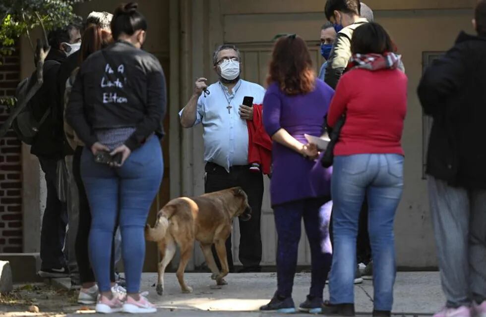 Father Guillermo (C) of Cristo Obrero parish talks to social leaders at Padre Carlos Mugica neighborhood, also known as Villa 31 shantytown, before a press conferente during the lockdown imposed by the government against the spread of the new coronavirus, COVID-19, in Buenos Aires,, on May 18, 2020. - The Crisis Committee of Villa 31 gave a press conference to demand that the health emergency be declared immediately in Buenos Aires as a result of the alarming progress of the novel coronavirus. (Photo by JUAN MABROMATA / AFP)