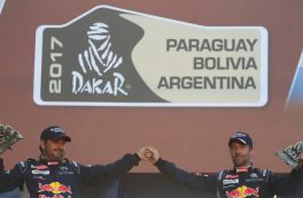 Peugeot's driver Driver Sebastien Loeb of France, right, and co-driver Daniel Elena of Monaco, celebrate with their 2017 Dakar Rally second place trophy in Buenos Aires, Argentina Saturday, Jan. 14, 2017.(AP Photo/Martin Mejia)