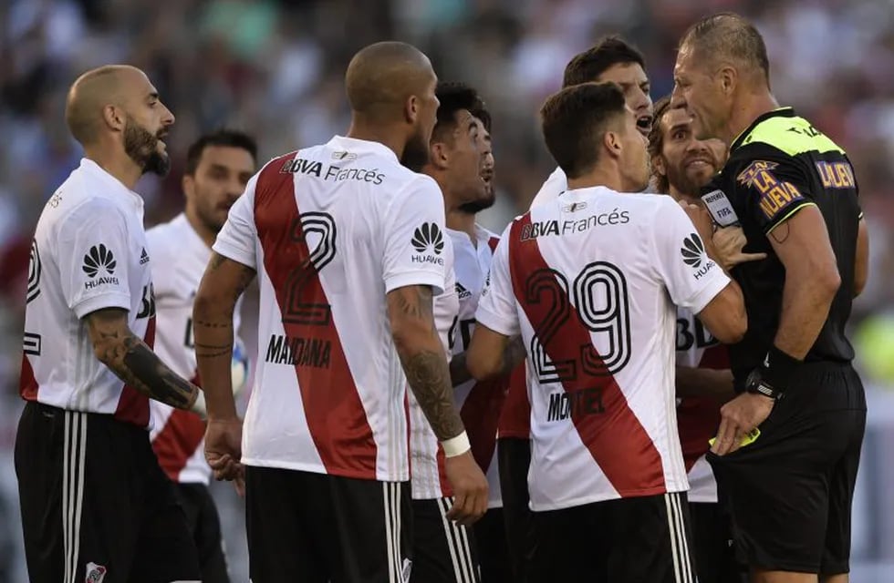 Referee Nestor Pitana (R) argues with River Plate footballers during the Superliga first division tournament derby match beetwen River Plate and Boca Juniors at Monumental stadium in Buenos Aires, Argentina, on November 5, 2017. / AFP PHOTO / JUAN MABROMATA