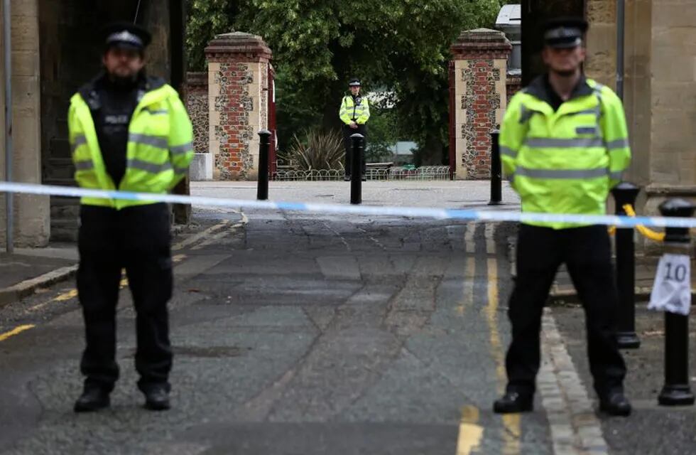 Police stand guard at the Abbey gateway of Forbury Gardens park in Reading town centre following Saturday's stabbing attack in the gardens, Sunday June 21, 2020. Thames Valley Police said a 25-year-old man from the town has been arrested and they are not looking for anyone else.  (Jonathan Brady/PA via AP)