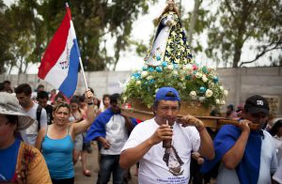la virgen azul religion iglesia catolicarnrnIn this Dec. 8, 2013 photo, a man takes a sip of mate as he helps transport the statue of Paraguayu2019s patroness, u201cOur Lady of Caacupe,u201d commonly called the u201cBlue Virginu201d through the slumu2019s parish that bears the name of the patroness, in Buenos Aires, Argentina. Thousands of Paraguayan immigrants living along the polluted Riochuelo river in Argentinau2019s capital celebrate their u201cBlue Virginu201d every year with a grueling but joyful 10-hour procession that winds through every corner of their slum. (AP Photo/Rodrigo Abd) buenos aires  paraguay procesion de nuestra seu00f1ora del caacupe comunidad paraguaya paraguayos