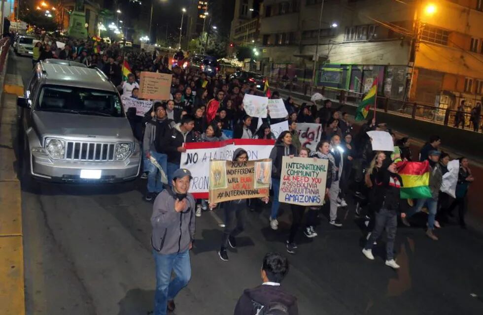 AME270. LA PAZ (BOLIVIA), 25/08/2019.- Centenares de personas, jóvenes en su mayoría, se movilizan este domingo en La Paz (Bolivia) para alzar la voz contra los incendios que han arrasado un millón de hectáreas de bosques y pastizales en la zona de la Chiquitania, en el este del país. La multitudinaria marcha recorrió esta noche las principales calles del centro de La Paz con pancartas que reclamaban \