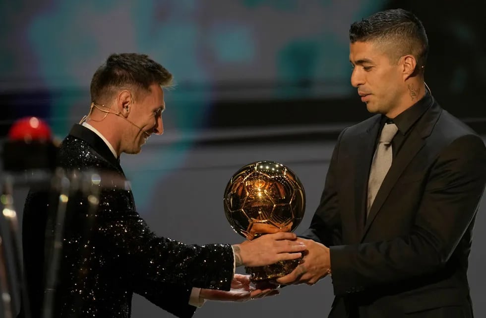 Una imagen que no se repetirá: Lionel Messi recibiendo el Balón de Oro de manos de su amigo Luis Suárez.