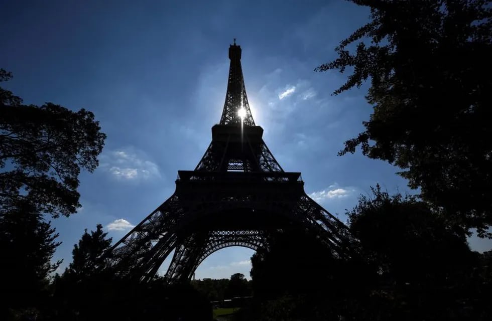 TOPSHOT - The sun shines between the structure of The Eiffel Tower in Paris on August 2, 2018. \r\nThe Eiffel Tower was turning away tourists for a second day as workers pressed a strike over a new access policy which they say is causing unacceptably long wait times for visitors. The monument has been closed since August 1, as unions locked horns with management over a decision to assign separate elevators to visitors with pre-booked tickets and those who buy them on site.\r\n / AFP PHOTO / GERARD JULIEN francia paris  Torre Eiffel cerrada por un conflicto laboral paro huelga protesta trabajadores de la torre eiffel contra nuevas politicas de acceso