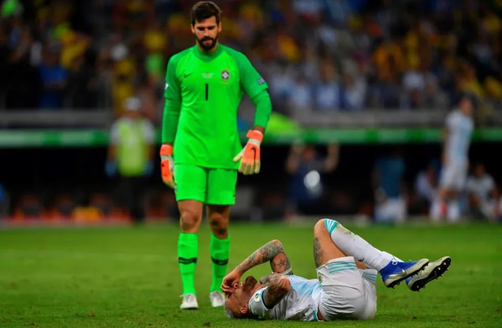 Argentina's Nicolas Otamendi (R) gestures on the ground near Brazil's goalkeeper Alisson during their Copa America football tournament semi-final match at the Mineirao Stadium in Belo Horizonte, Brazil, on July 2, 2019. (Photo by Pedro UGARTE / AFP)