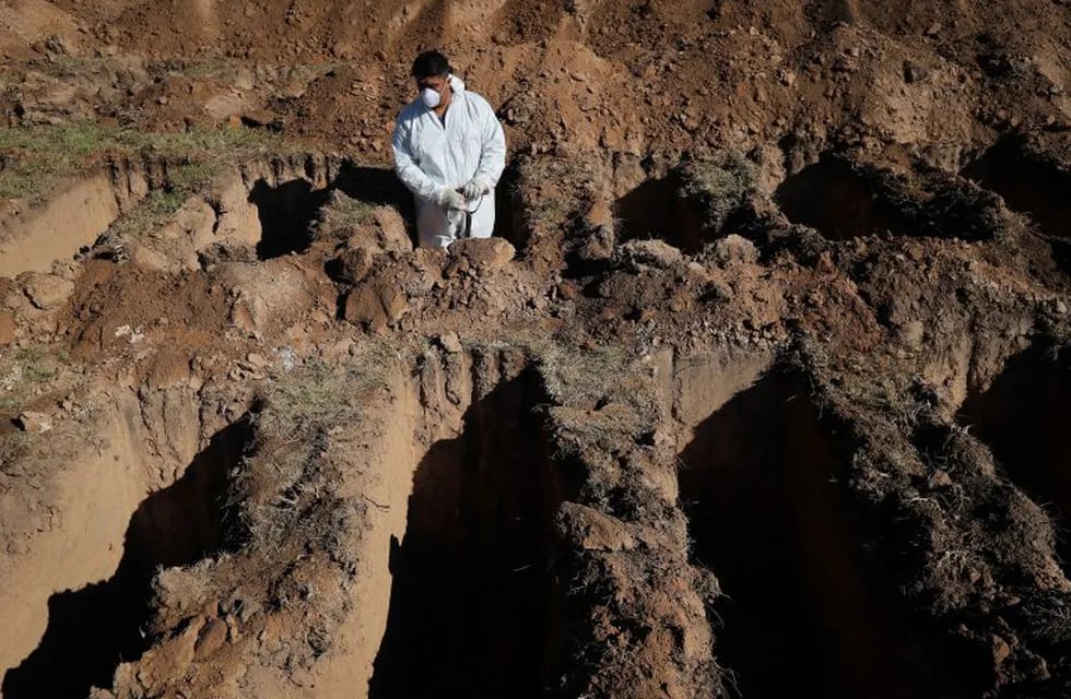 A cemetery worker pauses while digging graves at the San Vicente cemetery in Cordoba, Argentina, Tuesday, April 14, 2020. Six to seven times more graves than normal are being dug in Cordoba, as a precaution amid the deadly, new coronavirus health emergency, according to the Cordoba Municipal Workers and Employees Union Press Secretary Damián Bizzi. (AP Photo/Nicolas Aguilera)  fosas comunes cordoba