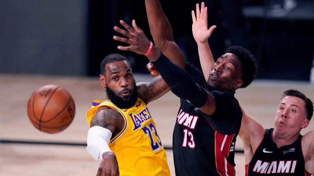 LeBron James, de Los Angeles Lakers, pasa la pelota esquivando a Bam Adebajo de Miami Heat  (AP Photo/Mark J. Terrill)
