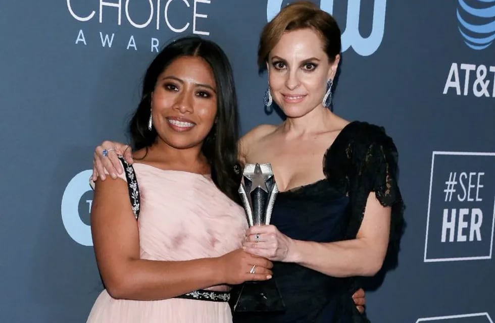 Actress Yalitza Aparicio (L) and Marina de Tavira (R) pose with the Best Movie trophy for \
