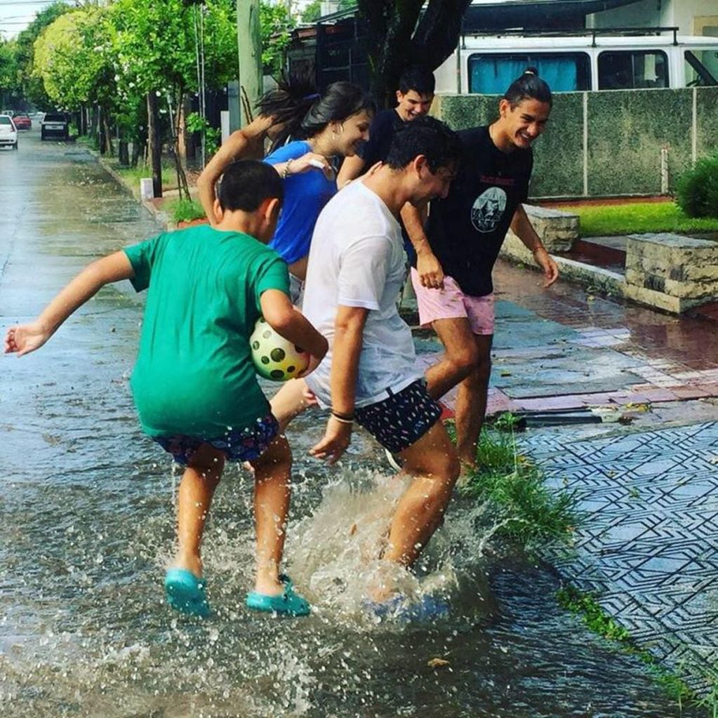 Las fotos de los adolescentes cordobeses jugando bajo la lluvia fueron tomadas por Juan Pablo Rodríguez, en barrio Los Naranjos.