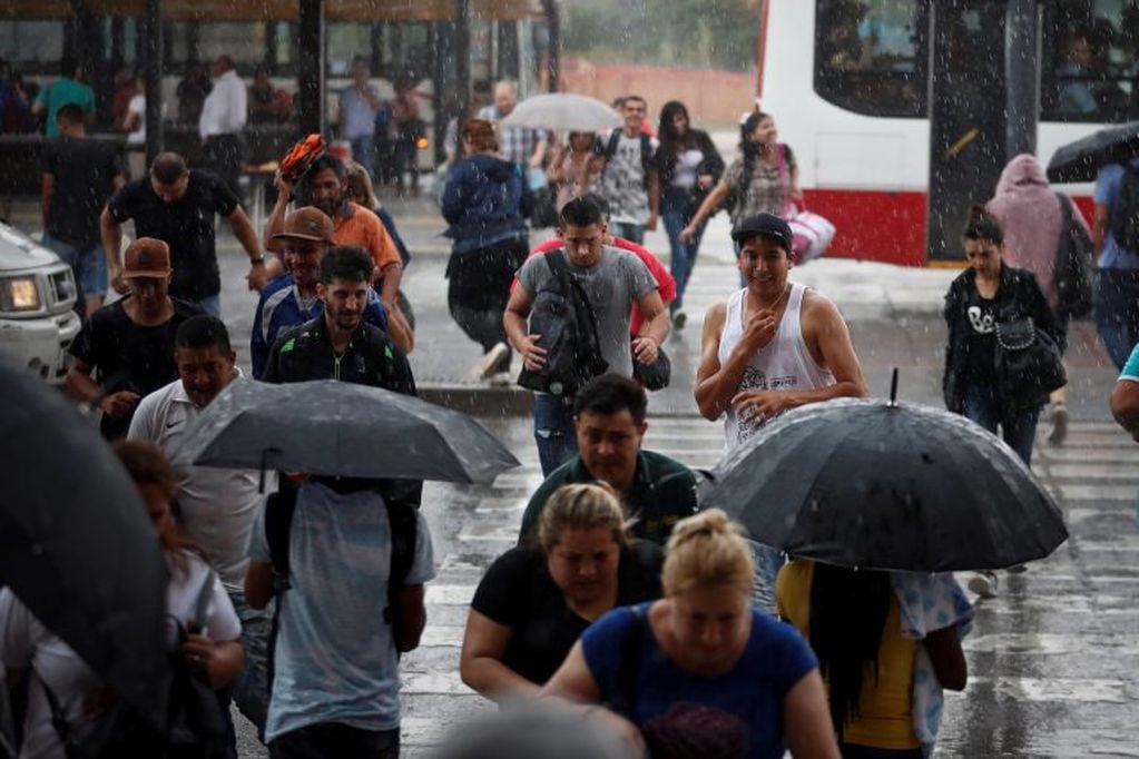 Personas corren a protegerse durante una intensa lluvia hoy, en la ciudad de Buenos Aires (Foto: EFE/Juan)