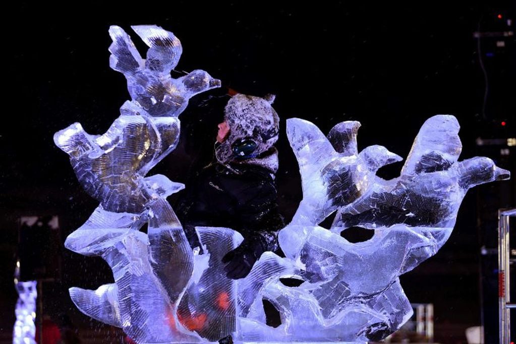 El escultor holandés Ludo Roders trabaja en su escultura de hielo "Flock of Birds" (Bandada) (Foto de JEAN-PIERRE CLATOT / AFP)