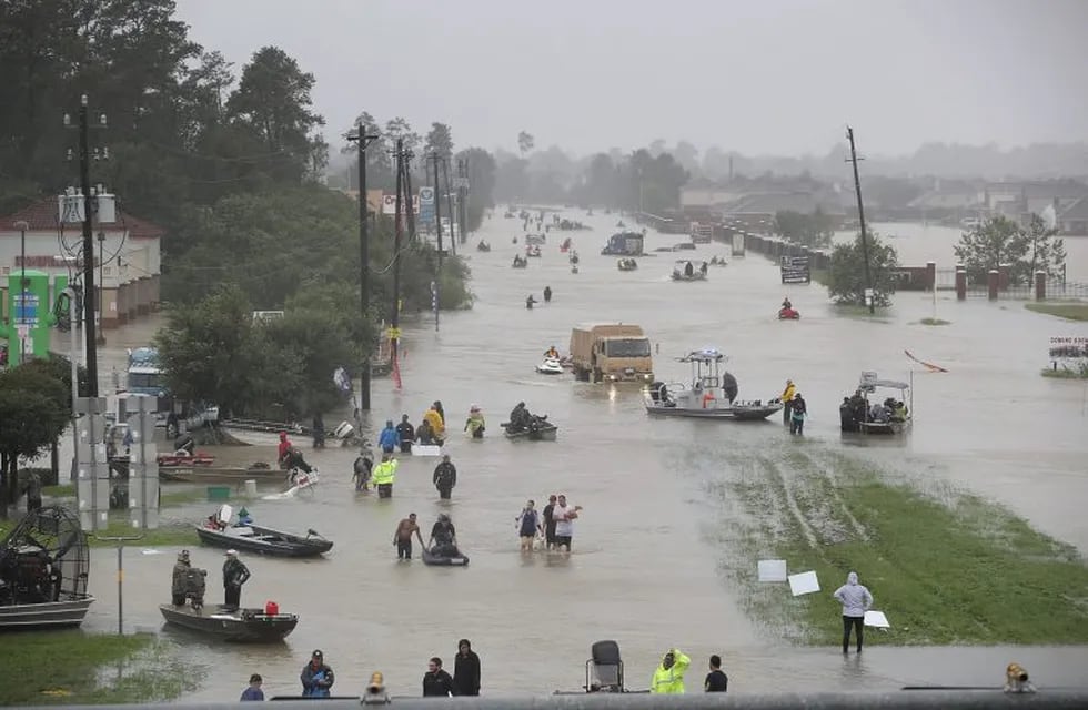 HOUSTON, TX - AUGUST 28: People walk down a flooded street as they evacuate their homes after the area was inundated with flooding from Hurricane Harvey on August 28, 2017 in Houston, Texas. Harvey, which made landfall north of Corpus Christi late Friday evening, is expected to dump upwards to 40 inches of rain in Texas over the next couple of days.   Joe Raedle/Getty Images/AFP\n== FOR NEWSPAPERS, INTERNET, TELCOS & TELEVISION USE ONLY ==