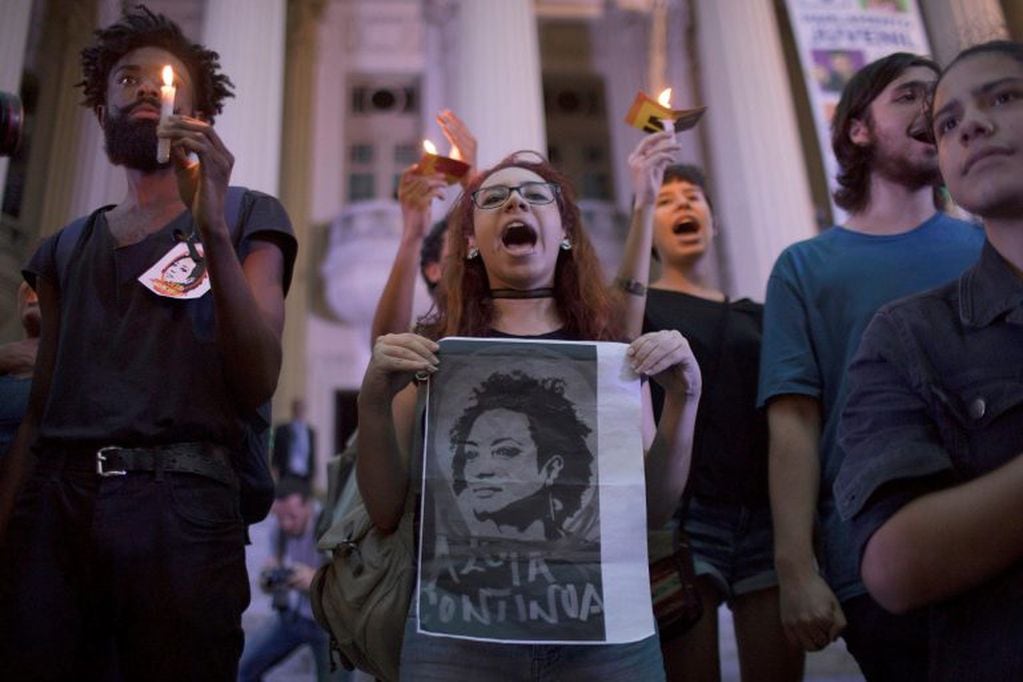 A woman shouts slogans as she holds a sign with the picture of councilwoman Marielle Franco during a protest against Franco's murder in Rio de Janeiro, Brazil, Friday, March 16, 2018. Franco was slain Wednesday night while returning from an event focused on empowering young black women. (AP Photo/Leo Correa)
