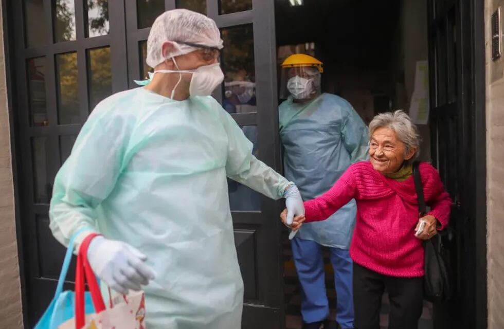 Medical staff evacuate an elderly woman from a nursing home after multiple residents of the facility tested positive for the new coronavirus, in Buenos Aires, Argentina, Wednesday, April 22, 2020. (AP Photo/Natacha Pisarenko)