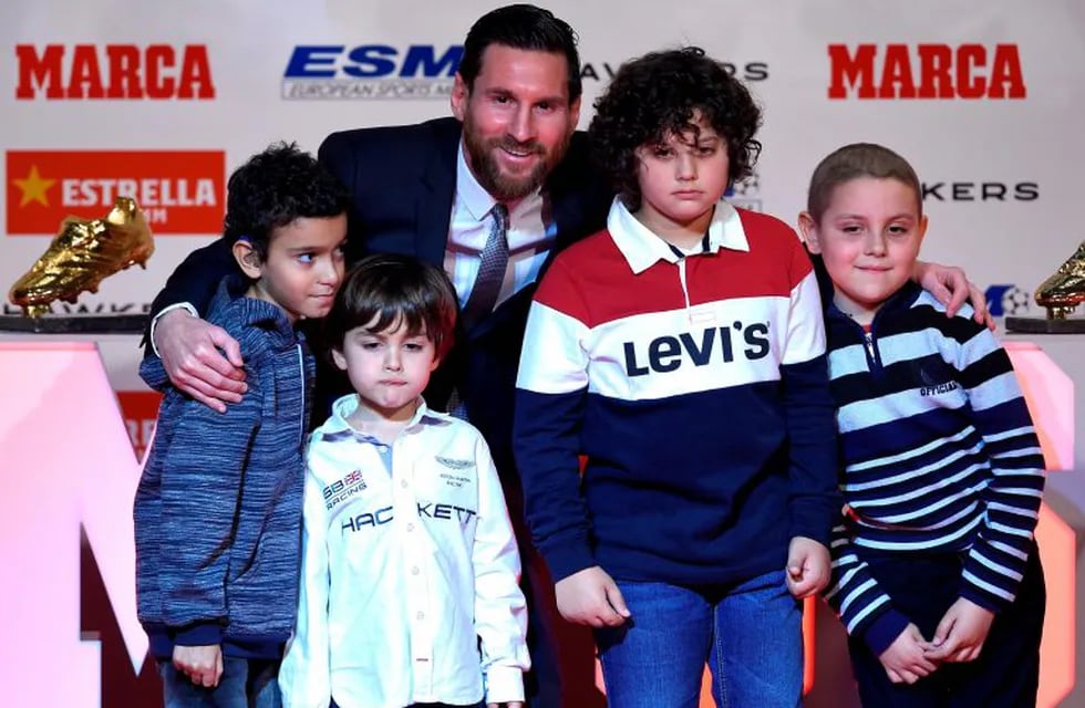 Barcelona's Argentinian forward Lionel Messi poses with children from de Sant Joan de Deu hospital after receiving the 2018 European Golden Shoe honoring the year's leading goalscorer during a ceremony at the Antigua Fabrica Estrella Damm in Barcelona on December 18, 2018. (Photo by LLUIS GENE / AFP) españa Barcelona lionel messi entrega premio botin de oro 2018 a futbolista del barcelona