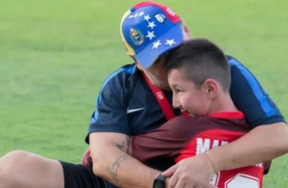 Diego Maradona junto a Alí, un niño sin piernas que deseaba conocer al astro argentino.