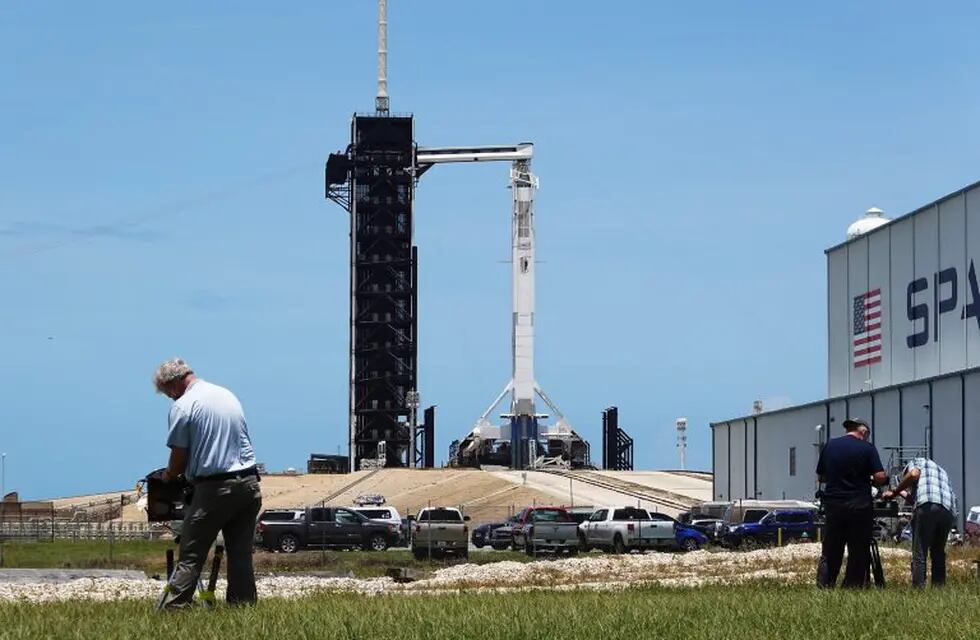 CAPE CANAVERAL, FLORIDA - MAY 29: Photographers setup remote cameras as the SpaceX Falcon 9 rocket with the Crew Dragon spacecraft attached is seen on launch pad 39A at the Kennedy Space Center on May 29, 2020 in Cape Canaveral, Florida. After scrubbing the first attempt at launch NASA astronauts Bob Behnken and Doug Hurley are scheduled to try again on Saturday and if successful would be the first people since the end of the Space Shuttle program in 2011 to be launched into space from the United States.   Joe Raedle/Getty Images/AFP\n== FOR NEWSPAPERS, INTERNET, TELCOS & TELEVISION USE ONLY ==