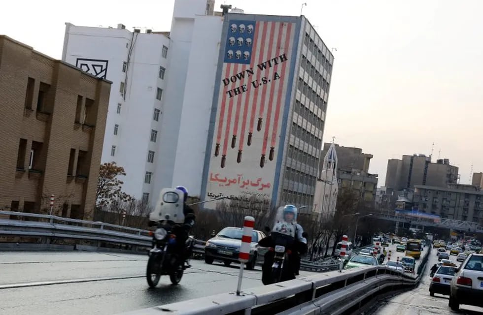 ABD01. Tehran (Iran (islamic Republic Of)), 07/01/2018.- Iranians drive past an anti-US wall painting 'Down with the USA' in Tehran, Iran, 07 January 2018. Media reported that after several days of anti-regime protests in Iran, now the situation on streets is back to normal. (Protestas, Teherán, Estados Unidos) EFE/EPA/ABEDIN TAHERKENAREH