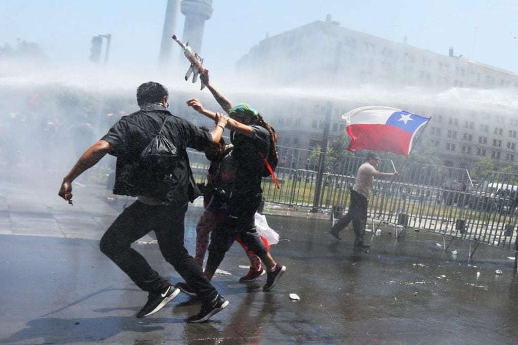 n grupo de encapuchados se enfrenta a la policía este martes, durante otra jornada de protestas, en Santiago de Chile (Chile). EFE/ Elvis González