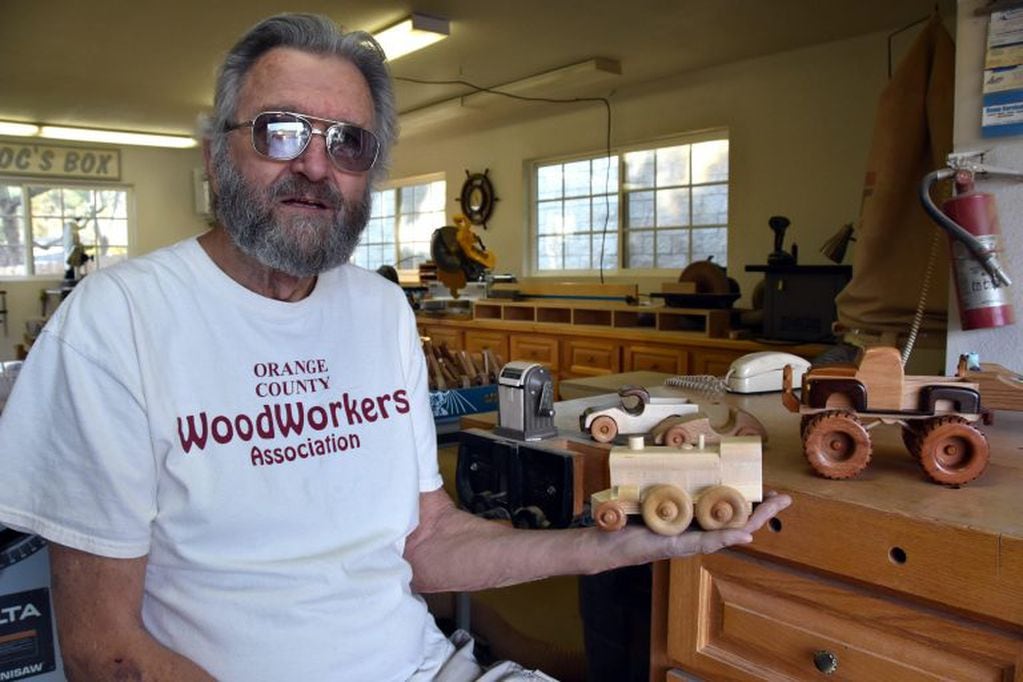El miembro de la organización no lucrativa Orange County Woodworkers de California, Ken Crandall, de 75 años, posa mostrando un juguete de madera (EFE)