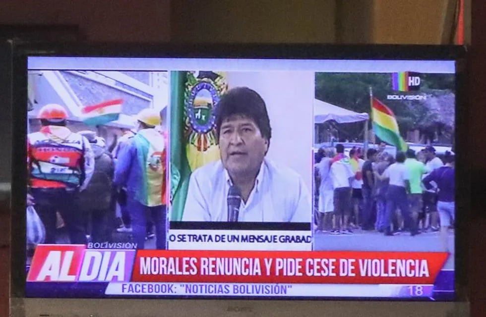 BOL112 LA PAZ (BOLIVIA), 10/11/2019.- Ciudadanos bolivianos observan en una pantalla la renuncia del presidente de Bolivia, Evo Morales, este domingo en La Paz (Bolivia). Morales confirmó que renuncia a la Presidencia después de casi 14 años en el poder, en un video desde algún lugar indeterminado, tras haber dimitido en cascada la mayoría de su Gobierno. El mandatario apreció en la televisión para anunciar su renuncia, tras lamentar un \