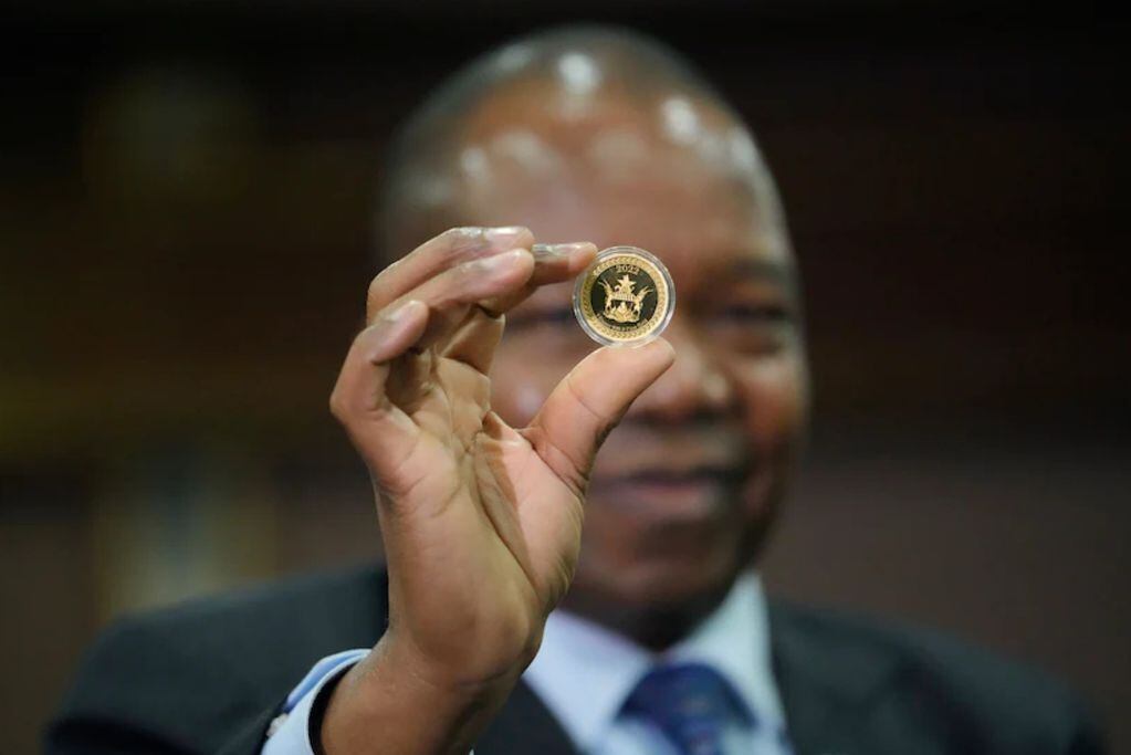 John Mangudya, gobernador del Banco de la Reserva de Zimbabue, sostiene una moneda de oro en el lanzamiento de la nueva moneda en Harare. (Tsvangirayi Mukwazhi / AP)