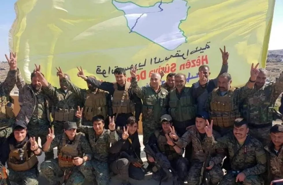 -FOTODELDIA- epa07458838 Un gruapo de milicianos de las Fuerzas de Siria Democrática (FSD), alianza armada que aglutina a kurdos y árabes, celebran la conquista de Al Baguz junto a su bandera amarilla, en la que sobresale un mapa de Siria. Las milicias kurdas que se enfrentaban al grupo yihadista anunciaron el esperado final del dominio territorial del EI a primera hora de la mañana, después del final de los combates que se adentraron en la noche del viernes en esta pequeña población rural cercana a la frontera iraquí. EFE/ STR MEJOR CALIDAD DISPONIBLE