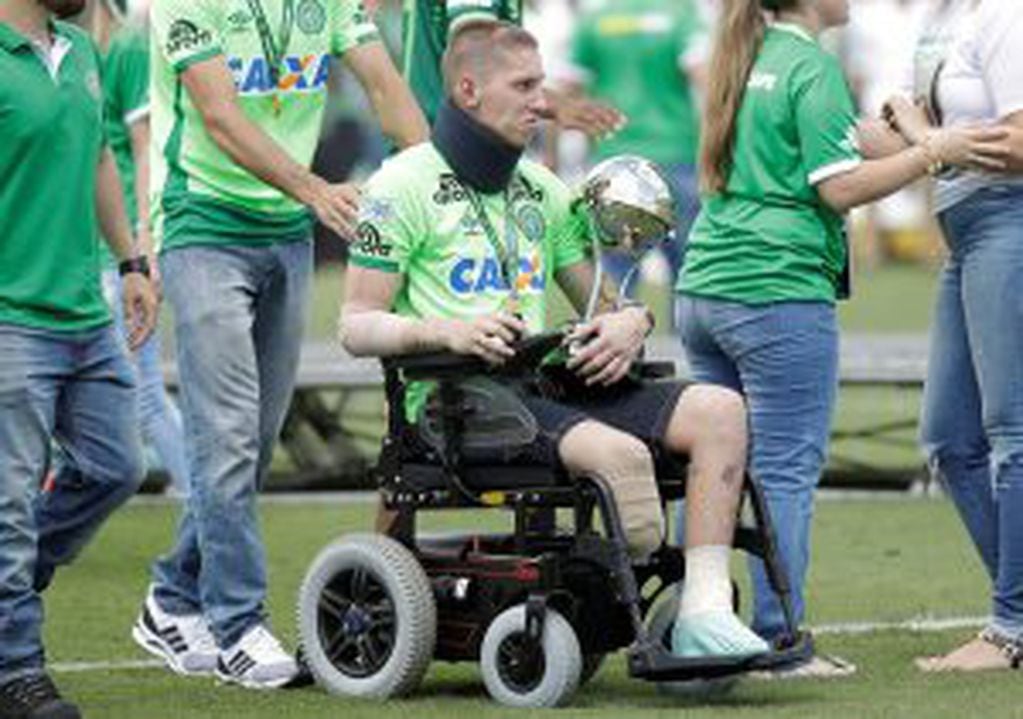 Chapecoense goalkeeper Follmann, one of the three players that survived the air crash almost two months ago, is wheeled on the pitch as he carries the Sudamericana trophy, during the Sudamericana trophy award ceremony prior to a match against Palmeiras, i