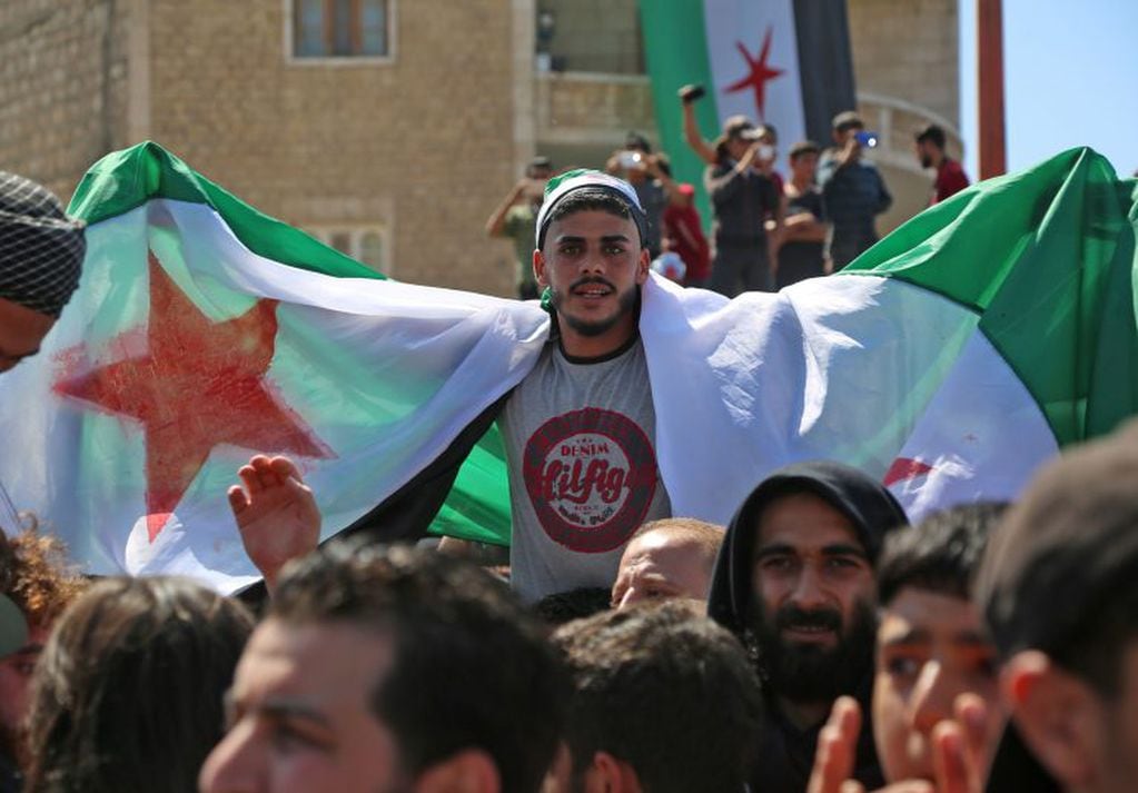 Manifestantes sirios agitan la bandera de la oposición en la ciudad de Idlib